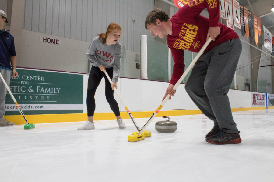 Students curling on ice rink